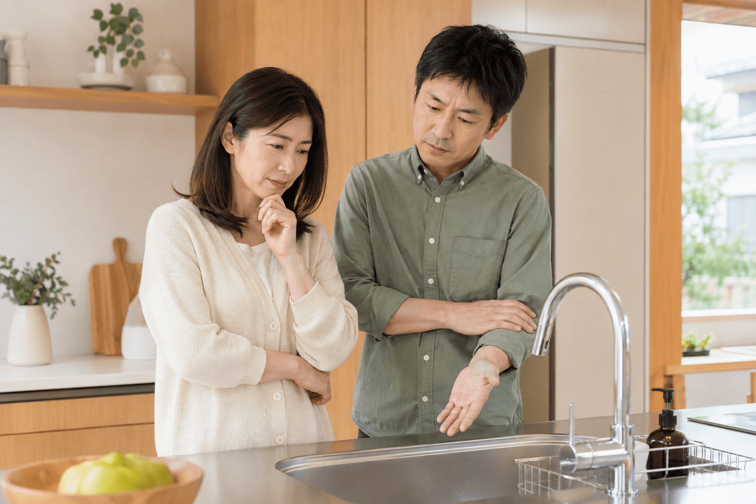 キッチンでお湯の様子を確認する夫婦